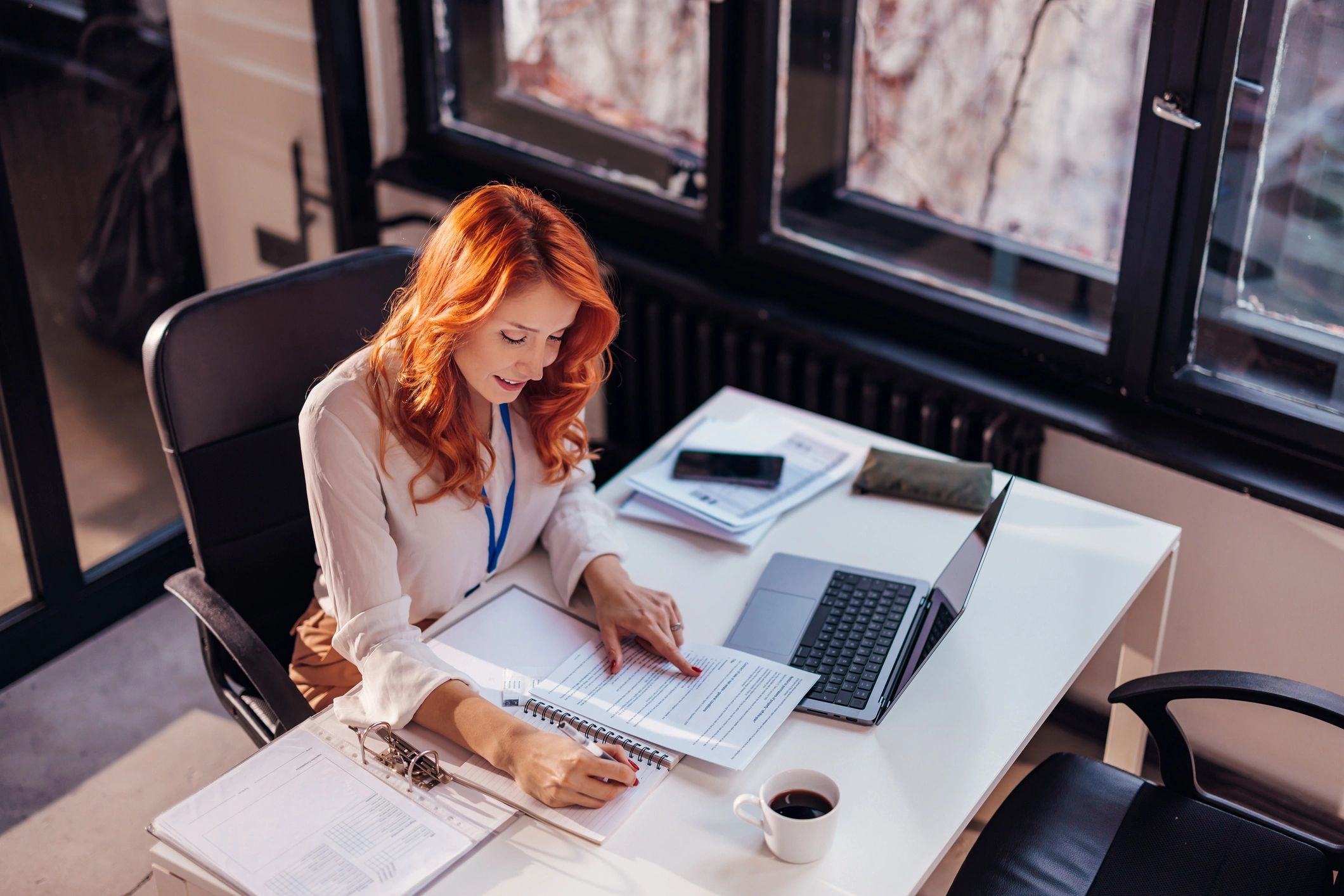 Bookkeeping professional working at a laptop and reviewing paperwork